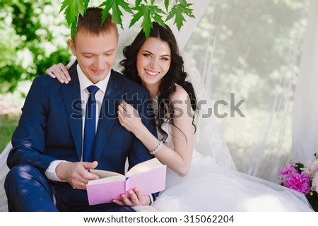 Bride and groom outdoors smiling cuddling and reading books, decor, peonies, flowers, lifestyle, marriage, family, love