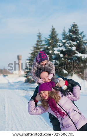 Young beautiful family in bright clothes winter fun jumping and running, snow, lifestyle, winter holidays