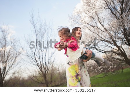 Mom and daughter dancing in nature together, the family, motherhood, entertainment, recreation, game