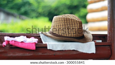 Fancy brown straww hat next to a couple of clothes, matches
