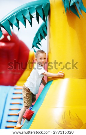 Little cool boy have fun and play on an inflatable trampoline