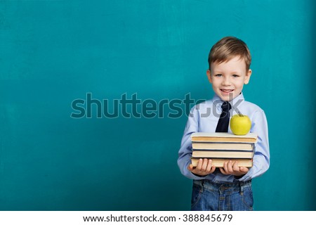 Book, school, kid. little student holding books. Cheerful smiling little kid against chalkboard. Looking at camera. School concept. Back to School