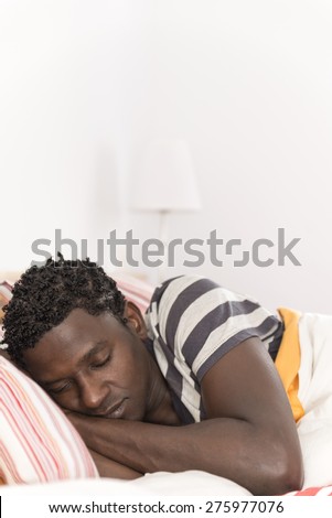 Peaceful african american man sleeping in bed at home in the bedroom