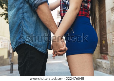Concept shot of friendship and love of man and woman: two hands over street urban. they are young