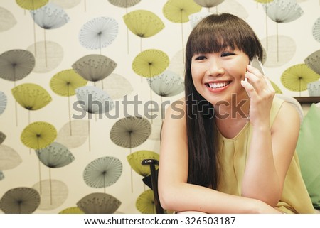 Bar smart casual young asian woman talking on smartphone. Happy female adult speaking on mobile phone.
