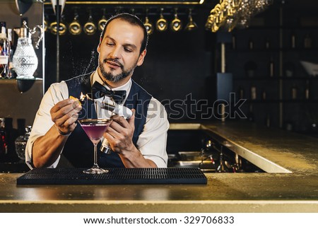 Expert barman is making cocktail at night club