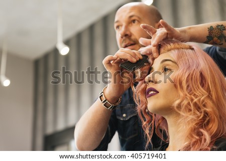 Beautiful woman getting haircut by hairdresser in the beauty salon.