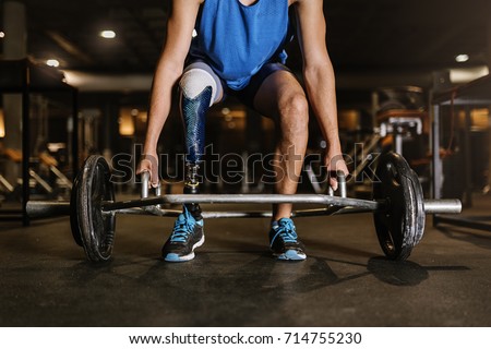Disabled young man training in the gym. Disabled Sportsman Concept.