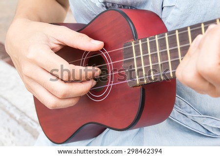 women playing ukulele at the beach