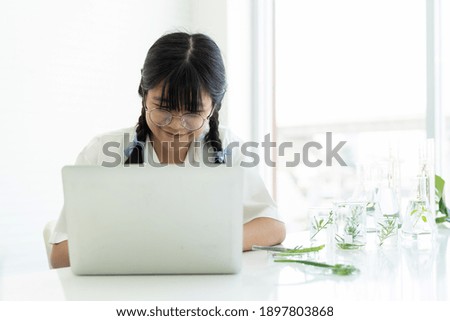 Asian girl scientists learning science and using computer laptop in the laboratory. Early development of children. Scientific experiment and Research concept