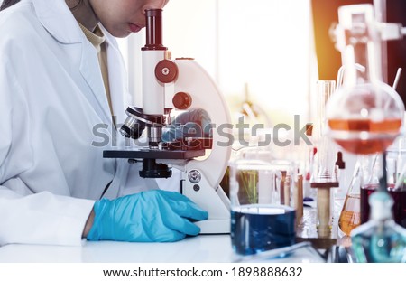 Scientists scientific experiment and analysis germs and bacteria with microscope, glassware and tube in the laboratory. Specialist working at lab. Researcher at laboratory