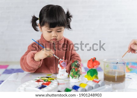 cute baby painting plaster puppet on the table, art concept