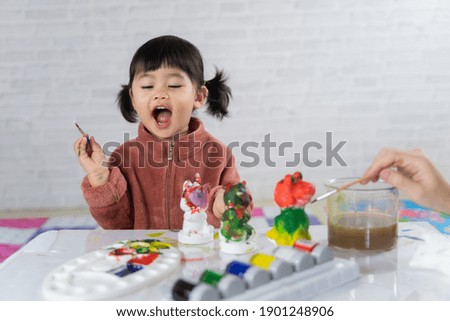 cute baby painting plaster puppet on the table, art concept
