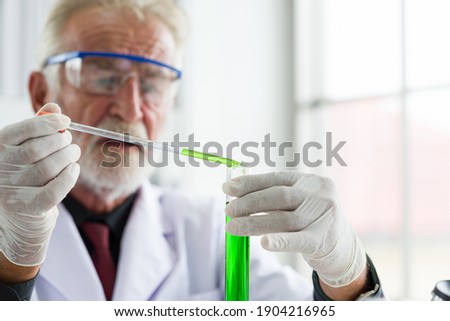 Senior male scientists wearing glasses and gloves doing scientific experiment and analysis germs bacteria in laboratory. Male specialist. Researcher working at laboratory