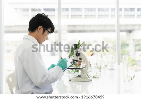 Scientists tests of plants in laboratory. Asian male scientists doing analysis for germs and bacteria with microscope in the laboratory. Scientific experiment. researcher and discovery concept