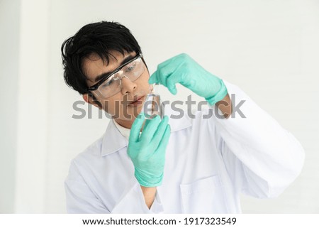 Scientists tests of plants in laboratory. Asian male scientists holding, doing analysis for germs and bacteria with glassware in the laboratory. Scientific experiment. researcher and discovery concept