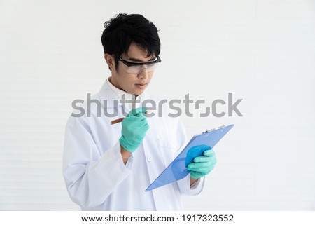 Man scientists doing analysis with clipboard in the laboratory. Asian male scientists wearing white uniform and glasses in the laboratory. Scientific experiment