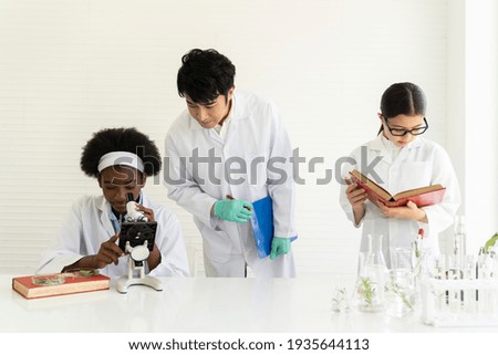 Asian man scientists and diversity children doing tests of plants in classroom. Group of diversity scientists learning science and doing analysis for germs and bacteria with microscope and glassware
