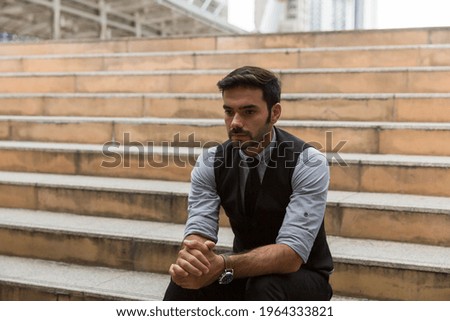 Businessman sitting at stairway outdoor with stressed and sad. Businessman losing job and sitting alone outdoor. Bankrupt business concept
