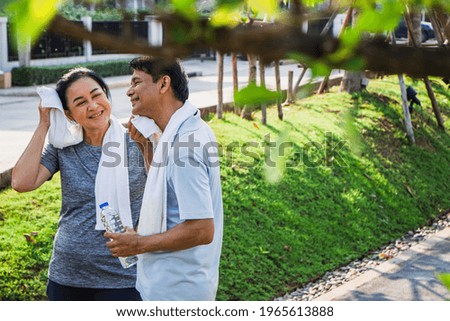 Couple older Asian men and women wear exercise clothes before their morning exercises.poritrait Old men and women use towels to wipe their sweat after jogging in the garden