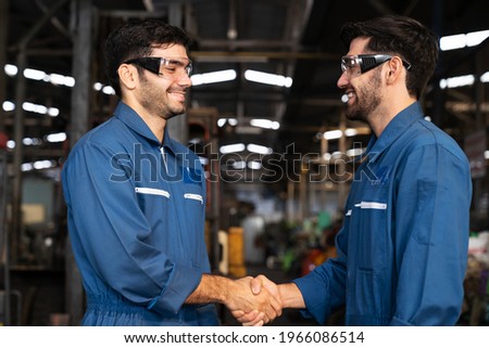 Factory male worker successful of their work while handshake with happy and smile in the industry factory. Training industry factory worker and maintenance inspection concept