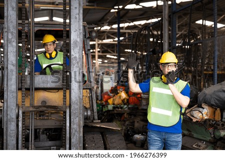 Factory worker talking on walkie-talkie for control forklift in warehouse, Workers freight transportation and distribution warehouse