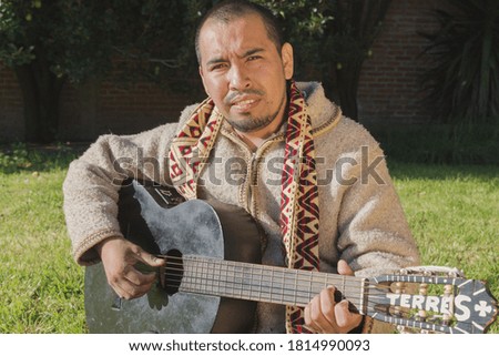 Musician holds guitar . A closeup portrait of a sacred man with traditional clothes