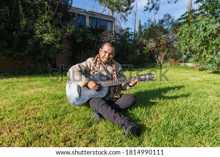 Musician holds guitar . A closeup portrait of a sacred man with traditional clothes