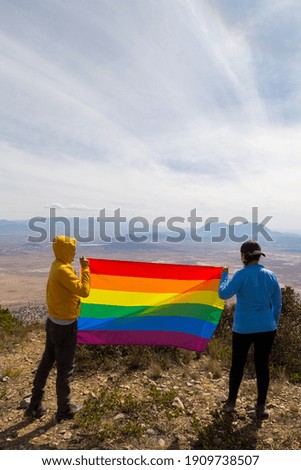 beautiful female young lesbian couple and rainbow flag, a symbol of the LGBT community, equal rights, beauty and love