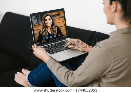 Back view of business latin woman talking to her mexican colleagues in video conference business team using laptop for a online meeting in video call working from home in Latin America