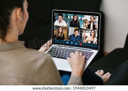 Back view of business latin woman talking to her mexican colleagues in video conference business team using laptop for a online meeting in video call working from home in Latin America