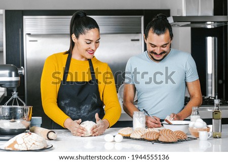 latin couple bakers preparing dough for baking mexican bread called Conchas in kitchen in Mexico city