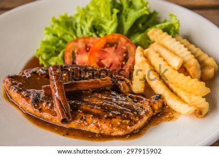 Chicken steak sauce on a plate with a white piece of chicken, potatoes and vegetables, focus on the front.