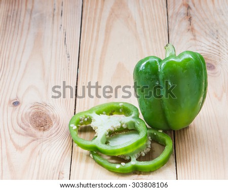 Green bell peppers, cut into pieces. Stacked on a wooden soft focus pepper.