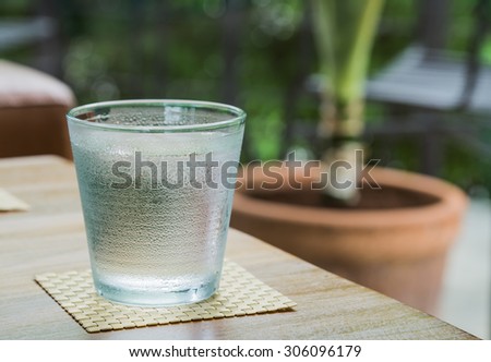 Glass of ice water with a glass of water. Put the glass on a wooden table at the back focal blur.