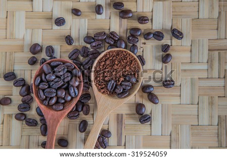 Coffee beans in wooden spoon.place on bamboo weave pattern.focus coffee beans on wooden spoon.