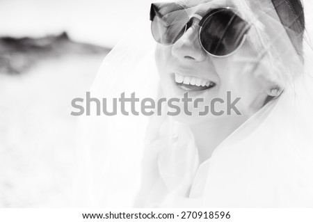 sexy  young beautiful girl  in sunglasses and white clothes on their honeymoon in Cyprus on the beach
