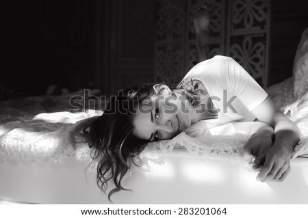 close-up portrait of a beautiful slim sexy cute girl on a bed with white linen in white top blond wake up and stretches and smiles