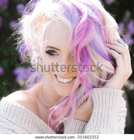 close-up portrait of a beautiful sexy young blonde girl hipster with lilac and pink hair  posing