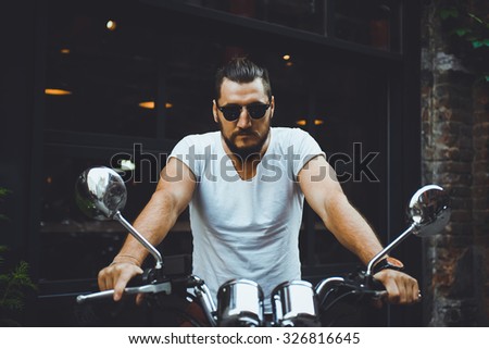 portrait young guy with a beard and mustache with sunglasses and white T-shirt posing on the street vintage man, fashion men, hipster street casual a motorcycle
