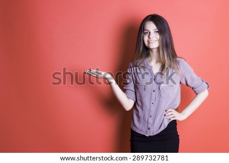Beautiful young girl on an orange background with a beautiful bright smile