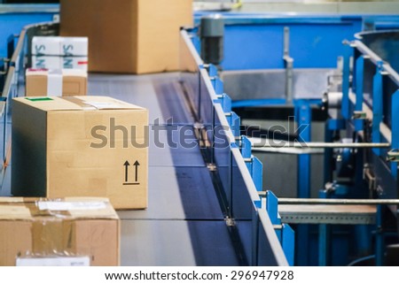 Parcels on conveyors with blurred industrial background