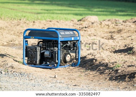 MOERS / GERMANY - NOVEMBER 03 2015 : Portable diesel power generator standing in a field and producing power