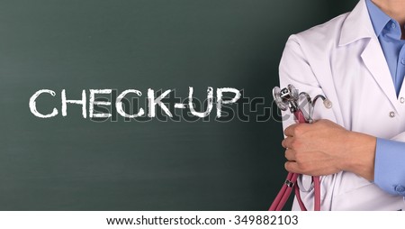 Doctor Standing front of Blackboard written CHECK-UP