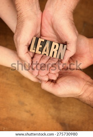 Very Old Vintage Letterpress letters in hands spelling out Learn