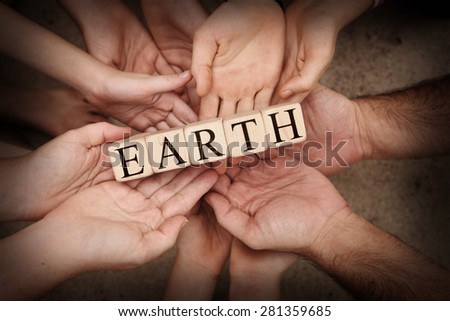 Team Holding Building Blocks in hands spelling out Earth
