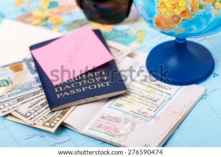 Passports, money, tickets, globe and map of the world as a vacation concept. Summer journey preparation. Planning holidays, cheking documents, choosing destination point, having fun.