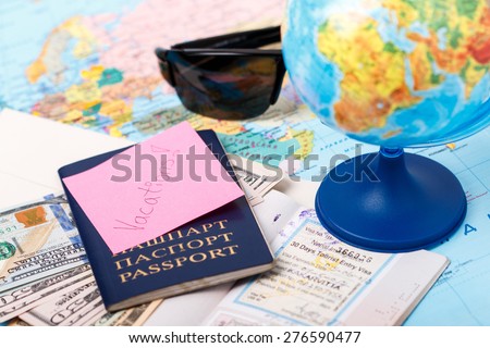 Passports, money, tickets, globe and map of the world as a vacation concept. Summer journey preparation. Planning holidays, cheking documents, choosing destination point, having fun.