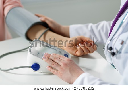 Female medicine doctor measuring blood pressure to patient. Patient communicates with physician doctor having medical examination. Medical concept. Hand of doctor and patient while pressure measuring