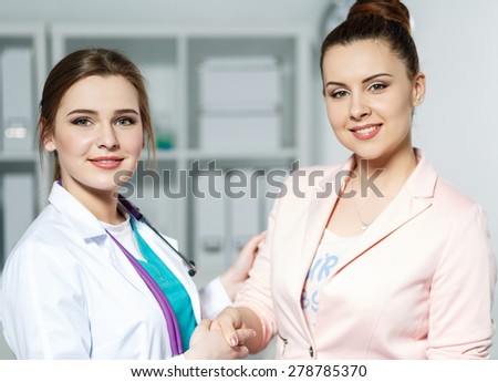 Beautiful female patient shaking hands with doctor. Partnership, trust and medical ethics concept. Handshake with satisfied client. Thankful handclasp for excellent treatment.